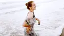 Berpose di sebuah pantai di Bali, Enzy tak hentinya menampakkan wajah yang ceria. Menggunakan pakaian bercorak bunga-bunga, perempuan kelahiran 1992 ini tampak begitu menawan dengan rambut yang dikuncir. (Liputan6.com/IG/@enzystoria)