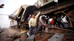 Pekerja mengevakuasi gerbong yang rusak parah usai kecelakaan yang melibatkan dua kereta penumpang di Palwal, India, Selasa (8/12). Menurut media setempat, kejadian itu menewaskan satu orang dan puluhan lainnya luka parah. (REUTERS/Anindito Mukherjee)