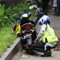 Petugas kepolisian menggembosi ban motor yang parkir di trotoar Jalan Kebon Sirih, Jakarta, Senin (17/7). Hal ini tindak lanjut maraknya pelanggaran lalu lintas di kawasan pedestrian Jalan Kebon Sirih. (Liputan6.com/Helmi Fithriansyah)