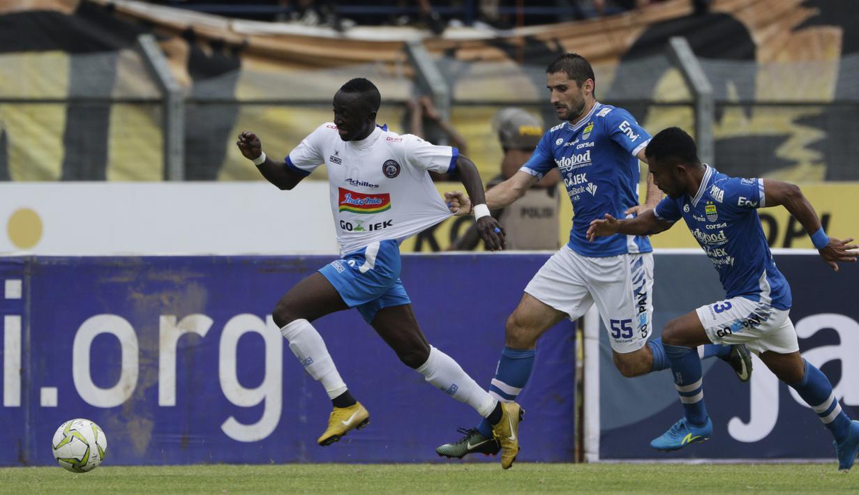 Gelandang Arema Malang, Makan Konate, ditarik oleh gelandang Persib Bandung, Srdan Lopicic, pada laga Piala Indonesia di Stadion Si Jalak Harupat, Bandung, Senin (18/2). Persib bermain imbang 1-1 melawan Arema. (Bola.com/Vitalis Yogi Trisna)