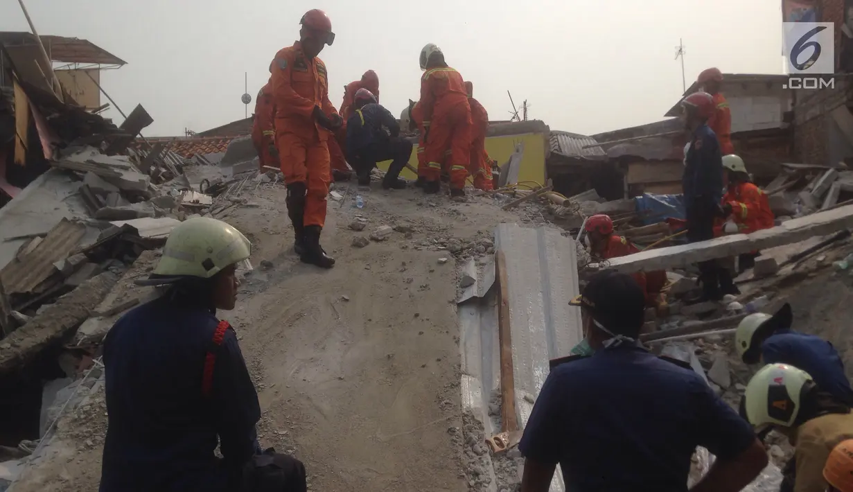 Sejumlah warga menyaksikan evakuasi korban rumah roboh di  Jalan Pulo, Tanah Tinggi, Johar Baru, Jakarta Pusa, Jumat (26/4). Enam orang masih terjebak dan tengah dalam proses evakuasi. (merdeka.com/Imam Buhori)