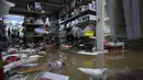 Barang-barang mengapung di atas air di dalam sebuah toko yang dilanda banjir saat hujan deras semalaman di Alges, tepat di luar Lisbon, Selasa (13/12/2022). Badai Atlantik menghantam semenanjung Iberia, meninggalkan jejak kehancuran pada Selasa, terutama di Ibu kota Portugal,  Lisbon, sebelum pindah ke timur ke Spanyol.  (AP Photo/Armando Franca)
