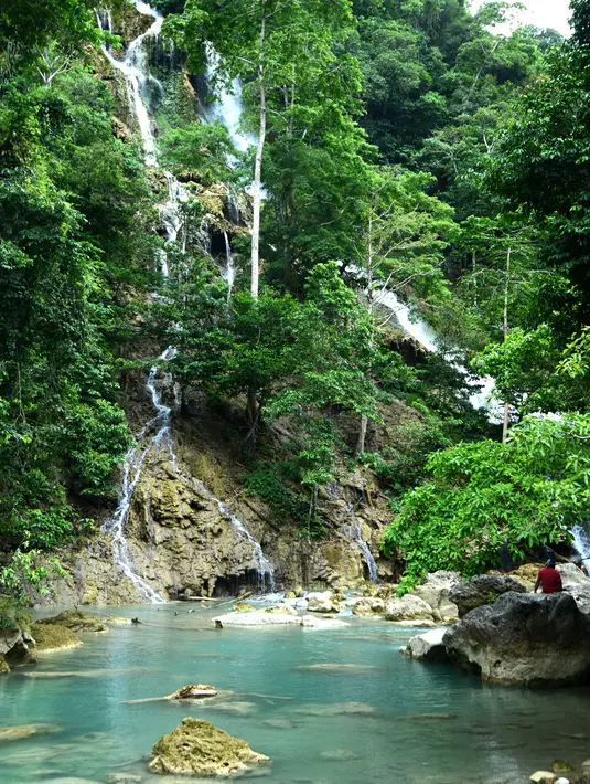 Suasana Air Terjun Lapopu yang terletak di Desa Hatikuloku, Kecamatan Wanokaka, Kabupaten Sumba Barat, Nusa Tenggara Timur (21/10). Air Terjun Lapopu memiliki kolam dengan air yang jernih kebiruan. (AFP Photo/Sony Tumbelaka)