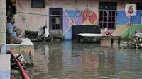 Warga memandangi banjir yang merendam RT 10/RW 05, Kampung Sawah, Kelurahan Rawa Terate, Cakung, Jakarta Timur, Kamis (20/2/2020). Hujan deras yang mengguyur Ibu Kota sejak malam tadi menyebabkan ratusan rumah di Kampung Sawah terendam banjir. (merdeka.com/Iqbal Nugroho)