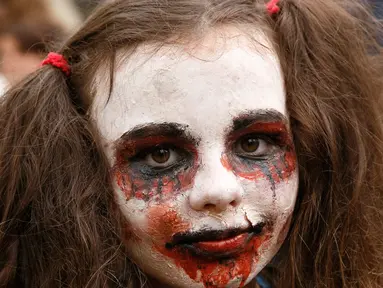 Seorang anak berpose dengan dandanan menyerupai zombie ketika berpartisipasi dalam 'Zombie Walk' di pusat Kota Kiev, Ukraina, 26 Oktober 2019. Menjelang perayaan Halloween pada 31 Oktober mendatang, warga di beberapa belahan dunia sudah mulai melakukan acara bertema horor. (AP/Efrem Lukatsky)