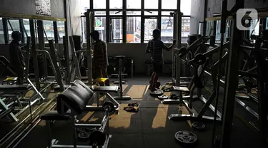 Pekerja merapikan tempat pusat kebugaran Mark Gym di kawasan Tebet, Jakarta, Selasa (5/10/2021). Meski demikian, tetap diberlakukan pembatasan seperti jumlah pengunjung maksimal 25 persen.  (Liputan6.com/Faizal Fanani)