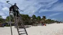 Seorang pria muda yang menyamar sebagai malaikat maut berada di pantai Puerto Morelos di Puerto Morelos, Quintana Roo, Meksiko, Sabtu (1/8/2020). Pria itu meminta wisatawan dan penduduk setempat kembali ke rumah karena pantai masih tertutup bagi pengunjung di tengah COVID -19. (ELIZABETH RUIZ/AFP)