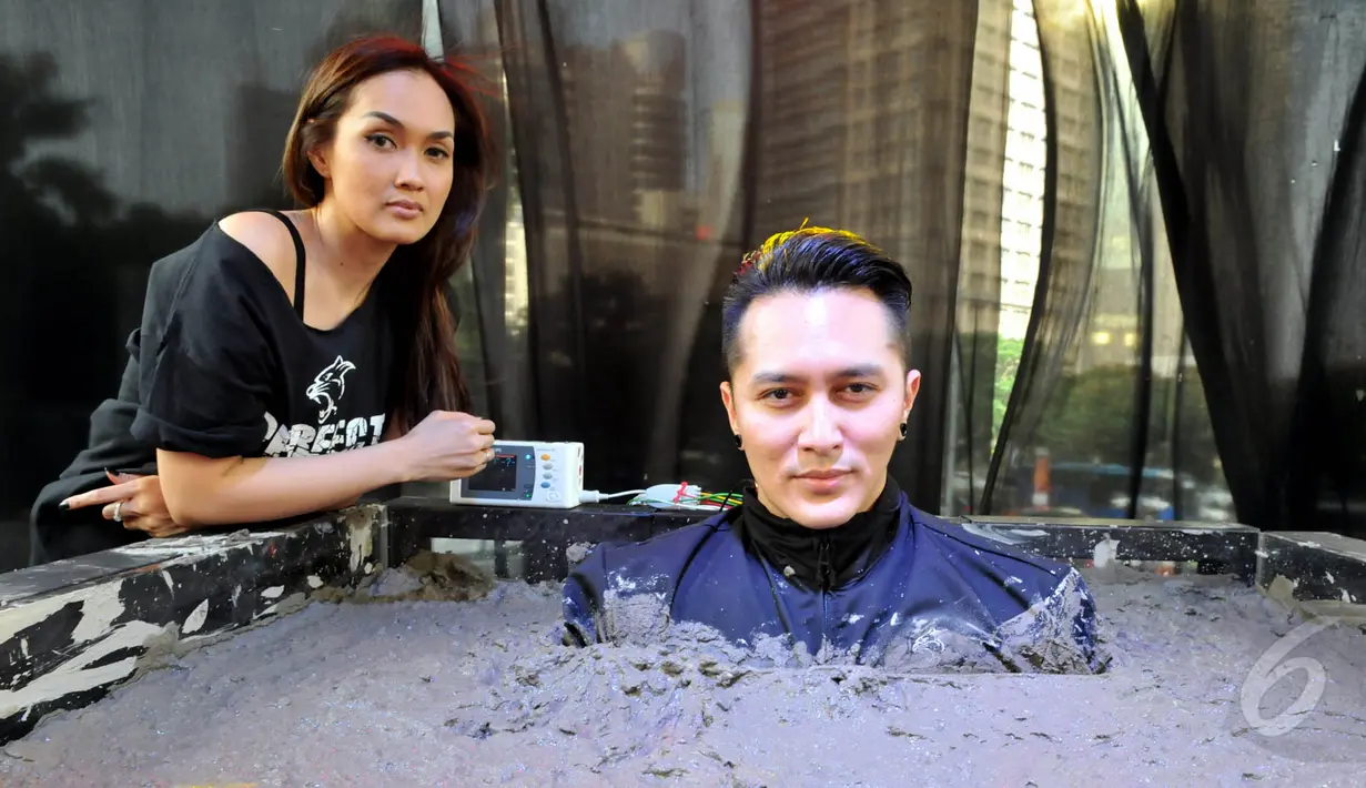 Ilusionis Demian Aditya melakukan aksi ekstrem dengan membiarkan dirinya dikubur hidup-hidup dengan semen cor, Jakarta, Jumat (22/5/2015). Sara Wijayanto tampak menemani Demian saat menjalani aksinya. (Liputan6.com/Panji Diksana) 