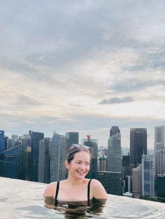 Penampilan manis Enzy Storia berenang dengan latar pemandangan gedung-gedung tinggi. Enzy mengenakan swimsuit berwarna hitam. [Foto: Instagram/enzystoria]