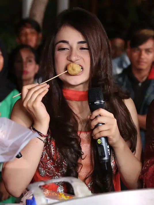 Tampak seru ketika Radhika bersama Indra Bekti dan pemeran lainnya mencicipi tahu bulat tersebut. Ia berada di sekitar mobil yang menjajakan tahu bulat tersebut sambil berbincang dengan sang penjual. (Bambang E. Ros/Bintang.com)