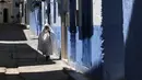 Seorang wanita berjalan di sepanjang gang kecil, Kota Chefchaouen, Maroko, Minggu (1/5). Keindahan kota Chefchaouen bahkan mengalahkan keindahan kota penuh cinta, Paris. (FADEL SENNA / AFP)