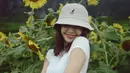 Berfoto di taman bunga matahari, Lisa tampak mengenakan crop top putih lengan pendek dengan detail serut di bagian kanan-kirinya. Ia padukan penampilannya ini dengan celana bermotif army dan bucket hat cokelat. Foto: Instagram.