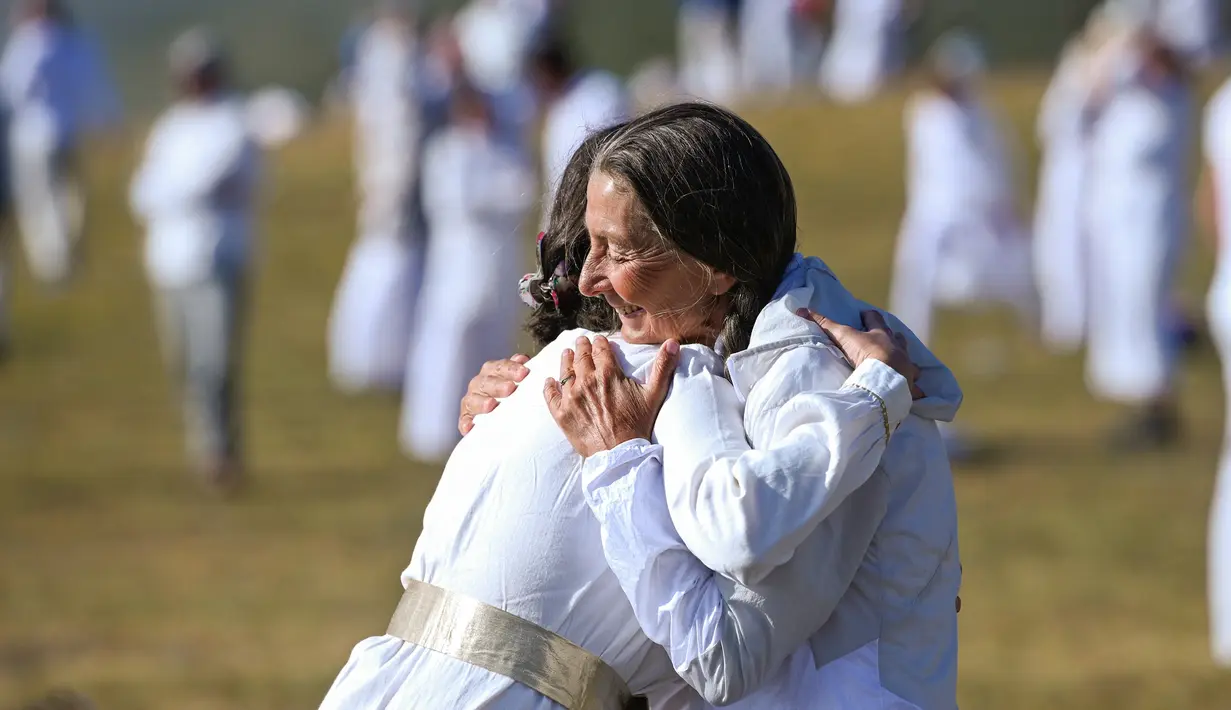 Anggota gerakan keagamaan internasional Persaudaraan Putih berpelukan saat merayakan tahun baru spiritual mereka di puncak Gunung Rila, dekat Danau Babreka, Bulgaria, 19 Agustus 2021. Tarian seperti kosmik dalam lingkaran konsentris menciptakan citra mencolok di Gunung Rila. (NIKOLAY DOYCHINOV/AFP)
