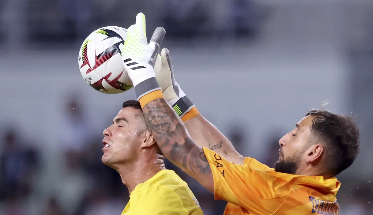 Pemain Al Nassr, Cristiano Ronaldo (kiri), berebut bola di udara dengan penjaga gawang PSG, Gianluigi Donnarumma dalam pertandingan uji coba yang berlangsung di Nagai Stadium, Osaka, Selasa (25/7/2023). (AFP/Paul Miller)