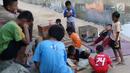 Anak-anak bermain di bantaran anak Sungai Ciliwung, Jakarta, Rabu (6/6). Meskipun tidak layak sebagai tempat bermain, namun lokasi itu menjadi tempat bagi anak-anak di kawasan tersebut untuk menunggu waktu berbuka. (Liputan6.com/Immanuel Antonius)