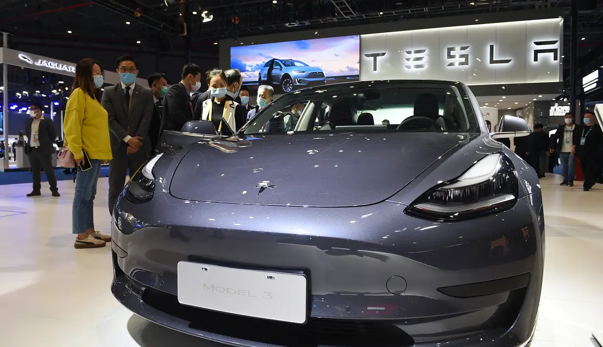 Orang-orang mengamati kendaraan Tesla Model 3 di area ekshibisi otomotif. Pameran Impor Internasional China (China International Import Expo/CIIE) ketiga di Shanghai, China timur (5/11/2020). (Xinhua/Zhao Dingzhe)
