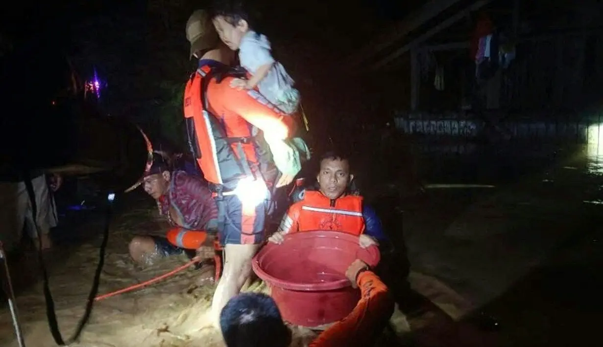 Penyelamat mengevakuasi orang-orang dari daerah banjir di Kota Ozamiz, Misamis Occidental, Filipina (25/12/2022). Dua orang tewas dan hampir 46.000 lainnya meninggalkan rumah mereka saat banjir pada libur Hari Natal. (Handout / Philippine Coast Guard (PCG) / AFP)