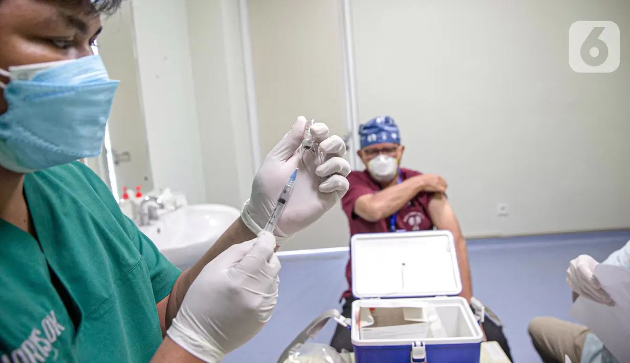 Petugas menyiapkan vaksin COVID-19 produksi Sinovac untuk disuntikkan kepada tenaga kesehatan saat kegiatan vaksinasi di RSCM di Jakarta, Senin (8/2/2021). Kementerian Kesehatan secara resmi memulai vaksinasi tenaga kesehatan di atas 60 tahun pada hari ini. (Liputan6.com/Faizal Fanani)