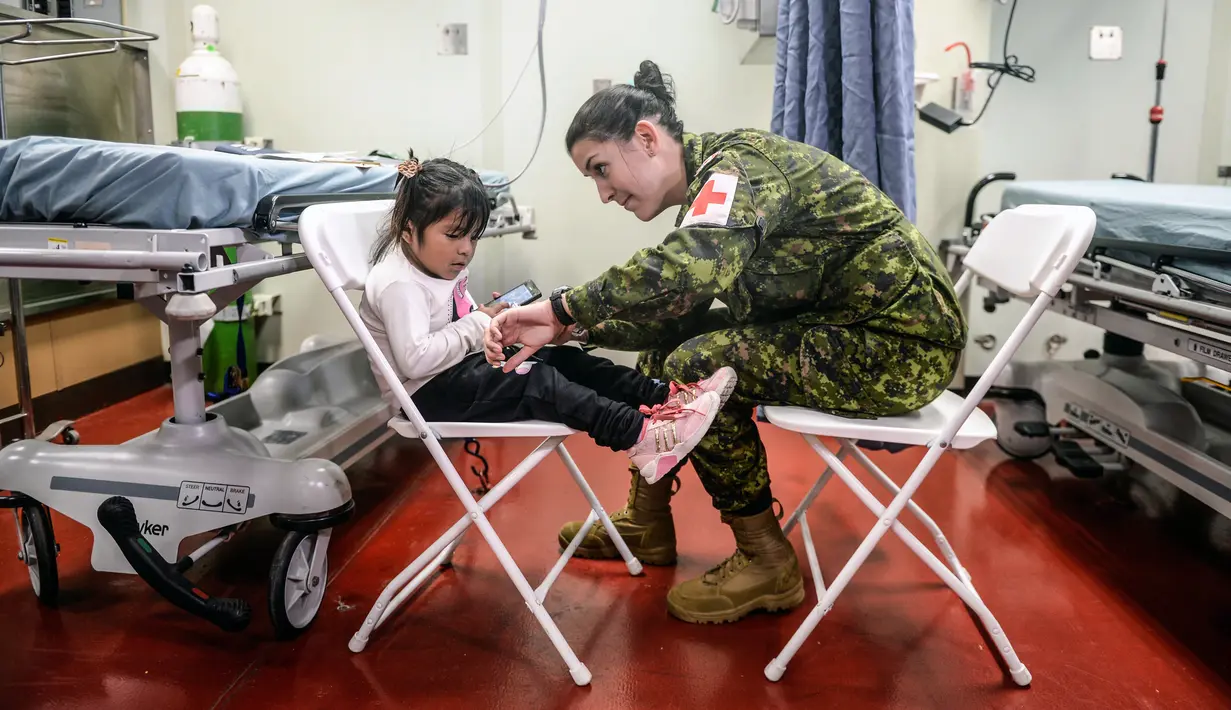 Angkatan Laut AS memeriksa seorang anak di atas kapal rumah sakit USNS Comfort yang berlabuh di wilayah Piura, Peru, 5 November 2018. Kapal rumah sakit ini dilengkapi alat medis paling canggih, dokter dan perawat berlisensi. (ERNESTO BENAVIDES / AFP)
