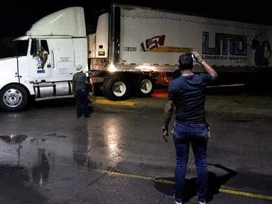 Sebuah kontainer truk trailer berisi lebih dari 100 mayat tak teridentifikasi dipindahkan dari Guadalajara menuju Jalisco di Meksiko, Senin (17/9). Kontainer pendingin itu memang setelah beberapa rumah duka di Guadalajara kepenuhan. (AFP/Ulises Ruiz)