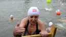 Bozena Cerna (88) keluar dari sungai Vltava setelah mengikuti kompetisi berenang Natal tahunan, di ibu kota Republik ceko, Praha, Rabu (26/12). Dalam menyemarakkan Natal, mereka mengikuti lomba renang di sungai bersuhu dingin. (Michal CIZEK / AFP)