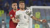 Pemain Timnas Italia, Ciro Immobile (kanan) mengontrol bola dibayangi Merih Demiral dalam pertandingan Grup A Euro 2020 antara Italia melawan Turki di stadion Olimpico, Roma, Sabtu (12/6/2021). (Foto: AP/Pool/Alberto Lingria)