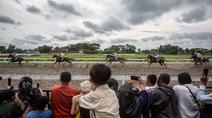 Orang-orang menonton balapan kuda dalam ajang Piala Raja Hamengku Buwono X 2025, kejuaraan balap kuda nasional tahunan yang memperebutkan trofi Sultan Hamengku Buwono X, di lintasan Sultan Agung, Bantul, Yogyakarta, pada Minggu 9 November 2025. Indonesia's Horse Racing (IHR) Piala Raja Hamengku Buwono (HB) X 2025 sukses digelar di Lapangan Pacuan Kuda Sultan Agung, DI Yogyakarta, Minggu (9/11/2025). (DEVI RAHMAN/AFP)