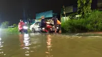 Warga mobilnya mogok akibat banjir di Jalan Raci Surabaya. (Dian Kurniawan/Liputan6.com)