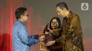 Pemimpin Redaksi Liputan6.com, Titis Widyatmoko (kanan) saat menerima penghargaan dari Otoritas Jasa Keuangan (OJK) untuk Kategori Media Online Terproduktif SubKategori Media Umum pada acara OJK Apresiasi Media Massa, Jakarta, Selasa (2/12/2025). (Liputan6.com/Helmi Fithriansyah)