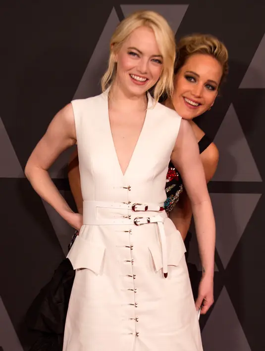 Awards ke-9 di Los Angeles, California, AS (11/11). Tingkah Jennifer Lawrence dan Emma Stone jadi perhatian awak media. (Photo by Jordan Strauss/Invision/AP) Aktris Jennifer Lawrence bersembunyi di belakang Emma Stone saat menghadiri acara Governors