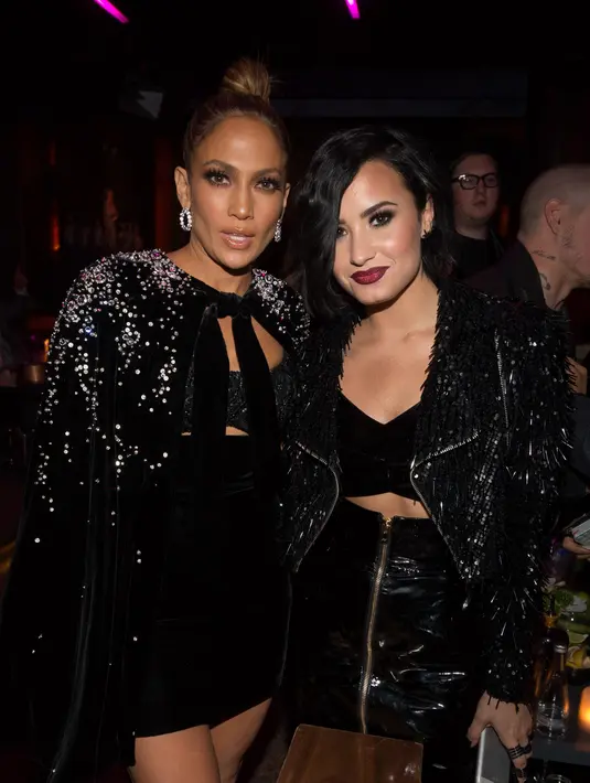 Busana dari Zuhair Murad kembali menemani Jennifer Lopez di acara ‘after party’. Ia pun berpose bersama Demi Lovato. (AFP/Bintang.com)