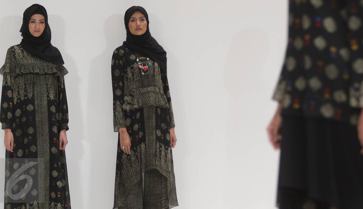 Model mengenakan busana karya desainer Itang Yunasz di Pasar Blok B Tanah Abang, Jakarta, Kamis (9/3). Dengan label Kamilaa, Itang menggunakan kain motif batik untuk gamis, kaftan, dan blus-blus panjang. (Liputan6.com/Immanuel Antonius)