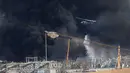 Helikopter tentara menjatuhkan air ke dalam api yang membakar gudang di Pelabuhan Beirut, Lebanon, Kamis (10/9/2020). Tentara Lebanon mengatakan kobaran api berkobar dari gudang penyimpanan minyak dan ban di area Bebas Pajak pelabuhan. (AP Photo/Hussein Malla)