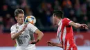 Duel Marcos Llorente dari Real Madrid dengan pemain Girona, Bernardo Espinosa pada leg kedua perempat final Copa del Rey di Stadion Municipal de Montilivi, Kamis (31/1). Real Madrid melangkah ke semifinal Copa del Rey  dengan skor 3-1. (AP/Manu Fernandez)