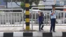 Warga memanfaatkan pagar pembatas jalan untuk menyeberang di kawasan Pasar Minggu, Jakarta, Kamis (5/4). Jembatan Penyeberangan Orang (JPO) yang tak kunjung diperbaiki membuat warga menyeberang lewat celah pagar pembatas. (Liputan6.com/Immanuel Antonius)