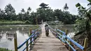 Warga melintasi jembatan apung saat menyeberangi Kali Cikarang Bekasi Laut (CBL) di Desa Sukamekar, Kecamatan Sukawangi, Kabupaten Bekasi, Jawa Barat, Kamis (17/2/2022). (merdeka.com/Iqbal S. Nugroho)
