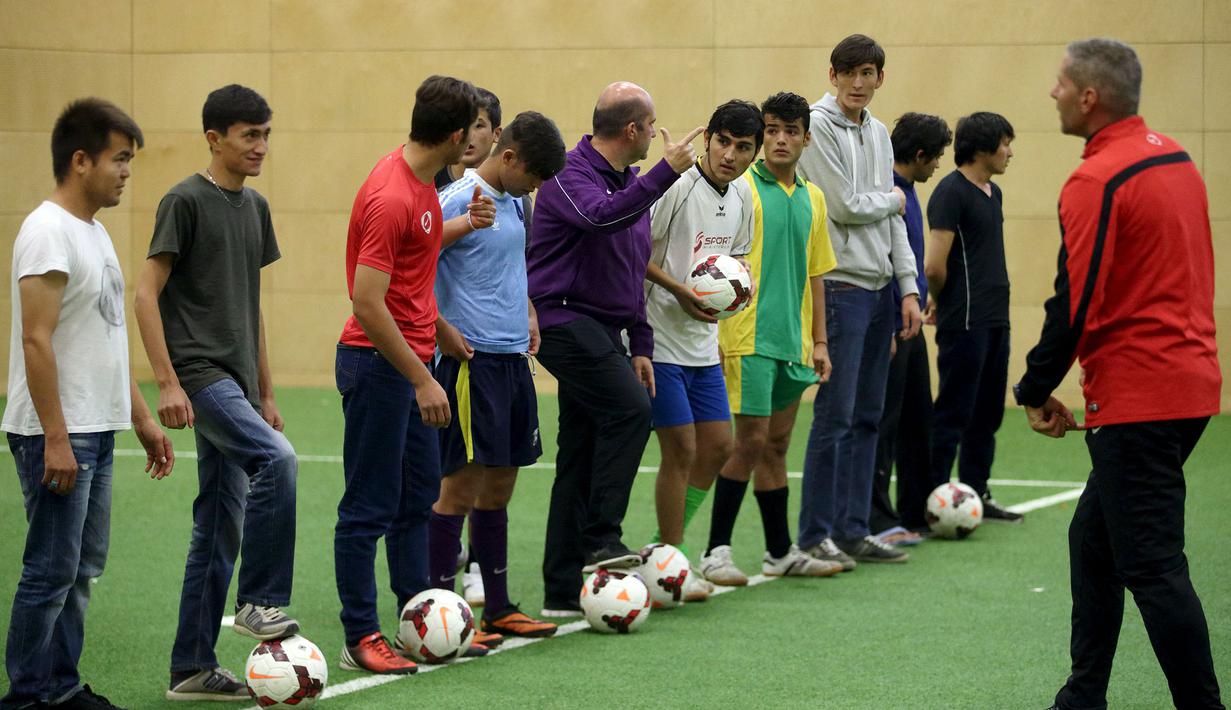 Para imigran mendapatkan instruksi dari pelatih sepak bola profesional yang berasal dari klub FK Austria Wien di Wina, Austria. (Reuters/Heinz-Peter Bader)