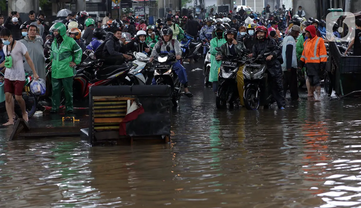Pengendara sepeda motor terjebak banjir yang menggenangi kawasan Jalan Wolter Monginsidi Jakarta dan sekitarnya, Sabtu (20/2/2021). Hujan yang mengguyur Jakarta sejak Jumat (19/2) membuat sejumlah titik di Jakarta terendam banjir. (Liputan6.com/Helmi Fithriansyah)