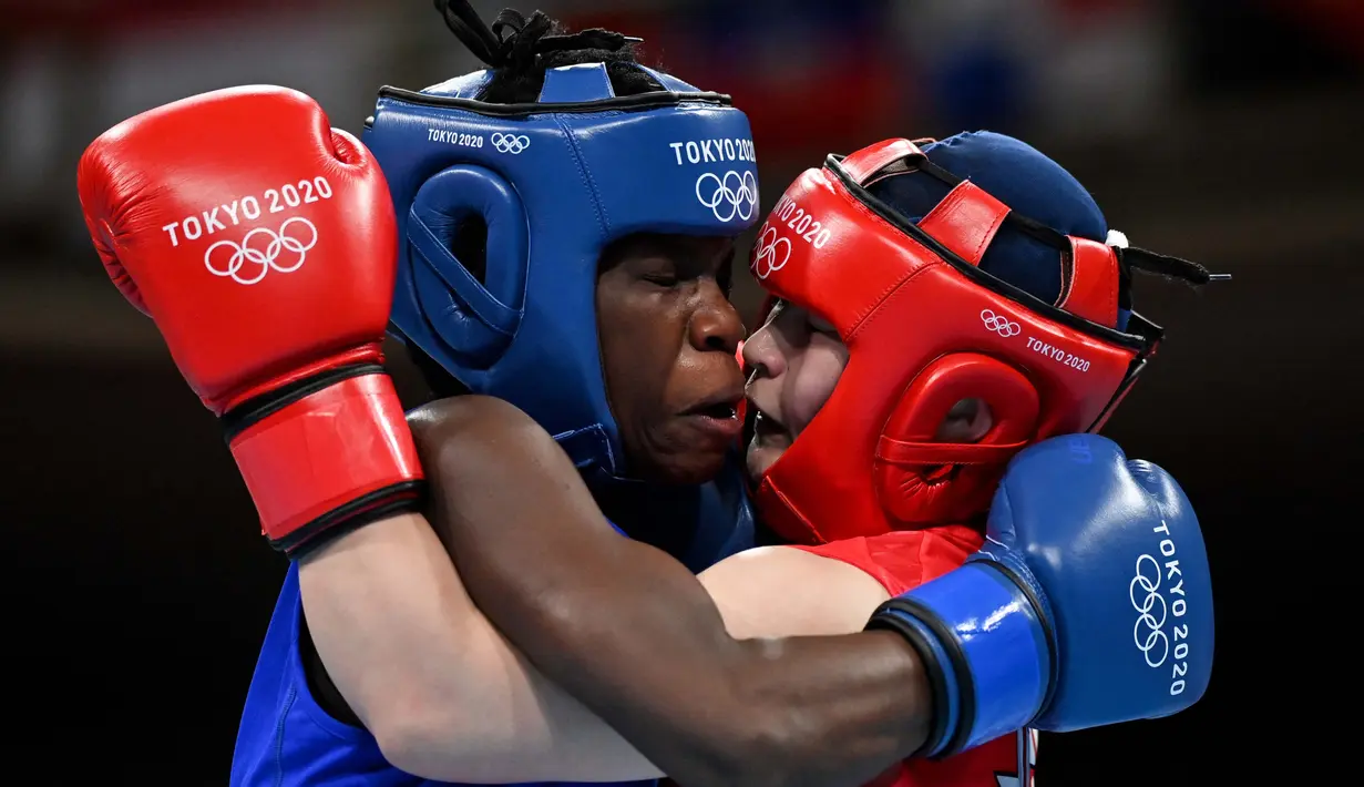 Petinju asal Jepang Tsukimi Namiki (kanan) bertarung dengan Catherine Nanziri asal Uganda dalam pertandingan tinju kelas terbang putri pada Olimpiade Tokyo 2020 di Kokugikan Arena, Tokyo, Minggu (25/7/2021). (Foto: AFP/Various Source/Luis Robayo)