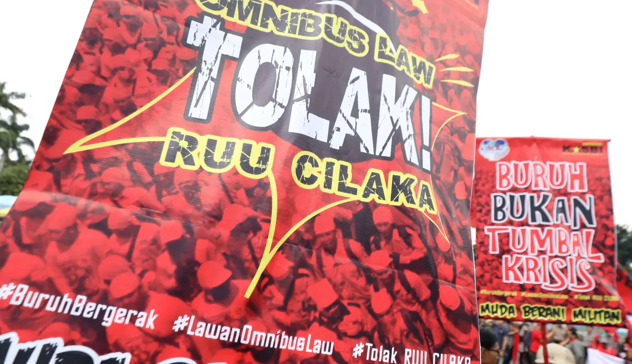 Poster bertuliskan tuntutan terlihat saat buruh yang tergabung dalam Gerakan Buruh Bersama Rakyat (Gebrak) berdemonstrasi di depan Gedung DPR, Jakarta, Senin (13/1/2020). Massa menyuarakan penolakan mereka terhadap Omnibus Law Rancangan Undang-Undang Cipta Lapangan Kerja. (Liputan6.con/Johan Tallo)
