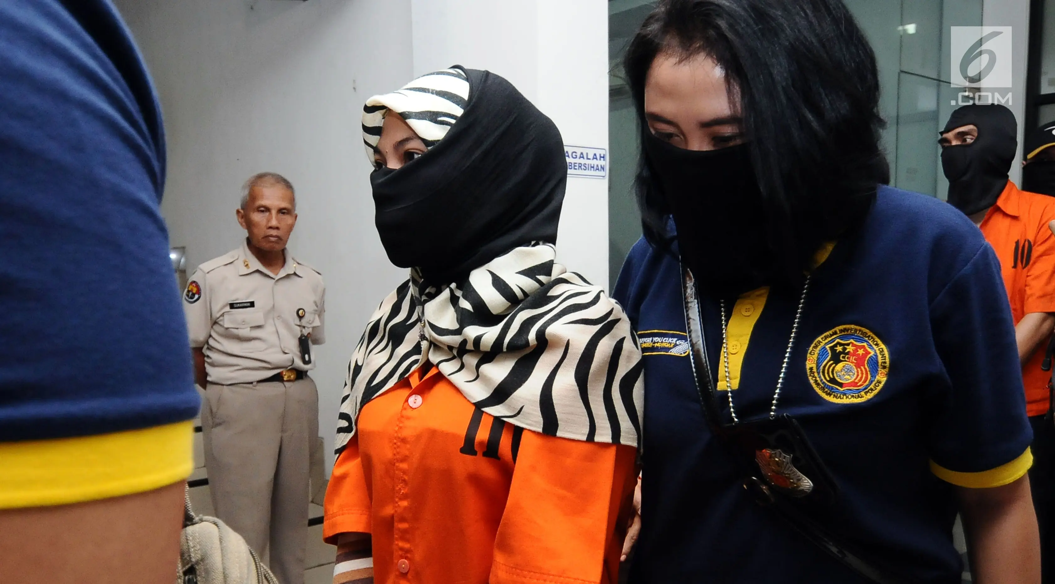 Salah satu tersangka kasus penyebaran ujaran bernada kebencian lewat internet digiring polisi usai rilis di Jakarta, Rabu (23/8). Tiga tersangka masuk dalam satu kelompok. (Liputan6.com/Helmi Fithriansyah)