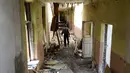 Seorang pria berjalan di dalam Sekolah Nomor 2 yang hancur terkena hantaman misil di kota Krasnogorivka yang terletak langsung di garis depan wilayah timur Ukraina, 21 Mei 2018. Tiga dari lima sekolah di kota tersebut sudah ditutup. (Aleksey FILIPPOV/AFP)