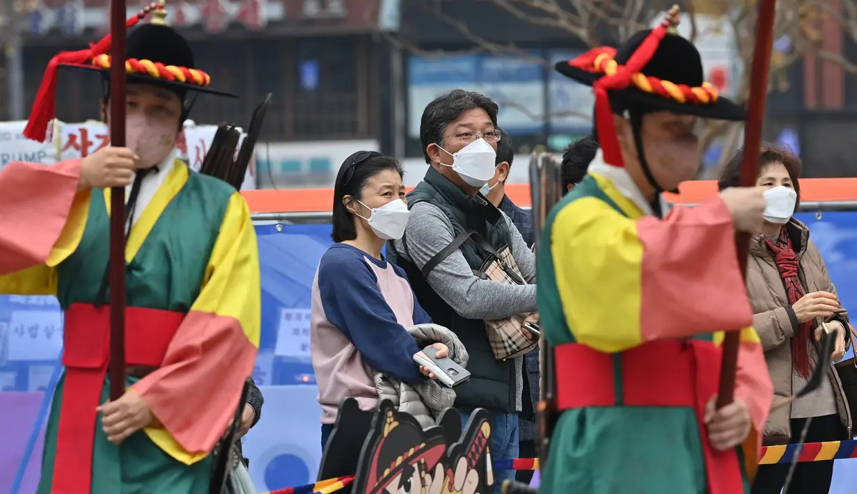Pengunjung yang mengenakan masker menyaksikan upacara pergantian penjaga istana di gerbang utama Istana Deoksugung di Seoul, Rabu (18/11/2020). Upacara Pergantian Penjaga Kerajaan diadakan mulai hari Selasa hingga Minggu, sebanyak tiga kali sehari (11:00, 14:00, 15:30). (Jung Yeon-je AFP)