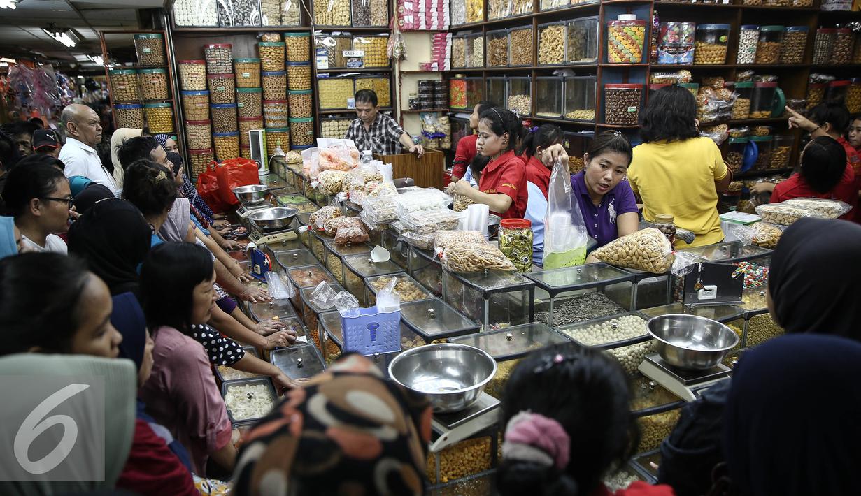 Sejumlah calon pembeli mengantre membeli kue kering di Pasar Jatinegara, Jakarta, Senin (27/6). Alasan warga membeli panganan khas lebaran di toko kue karena lebih praktis dan terjangkau harganya. (Liputan6.com/Faizal Fanani)