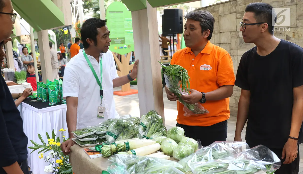 Kepala Bidang Keamanan Pangan Segar Badan Ketahanan Pangan, Apriyanto Dwi Nugroho (kaos putih) dan Managing Drirector PT Arla Indofood Ciptadi Sukono (kaos oranye) meninjau stand produk pangan organik ekspo Halo Organik di Tribeca Central Park, Jakarta (21/9/2019). (Liputan6.com/Angga Yuniar)