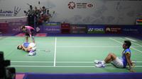 Ganda putra Indonesia Pramudya Kusumawardana (kanan) melihat pebulu tangkis Malaysia Aaron Chia memeriksa rekannya, Yeremia Rambitan terbaring di lapangan karena cedera lutut pada perempat final Indonesia Open 2022 di Istora Senayan, Jakarta, Jumat (17/6/2022). (AP Photo/Dita Alangkara)