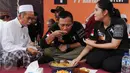 Calon Gubernur DKI Jakarta Agus Harimurti Yudhoyono bersama istrinya, Annisa Pohan menikmati nasi kebuli di Kampung Bidaracina, Jakarta, Rabu (30/1). Agus menggelar kampanye tatap muka dengan para warga di wilayah tersebut. (Liputan6.com/Gempur M Surya)