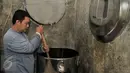 Pemilik produksi rumahan bir pletok, Endang Suratman mengaduk ramuan bir pletok di kawasan  perkampungan budaya Betawi, Setu Babakan, Srengseng Sawah, Jakarta, Senin (6/2). (Liputan6.com/Yoppy Renato) 