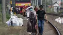 Sejumlah penumpang KRL Commuter Line terpaksa berjalan kaki menuju Stasiun Bojonggede, Bogor, Jawa Barat, Minggu (4/8/2019). Padamnya listrik di wilayah Jabodetabek mengakibatkan perjalanan KRL Commuter Line terhenti. (Liputan6.com/Helmi Fithriansyah)