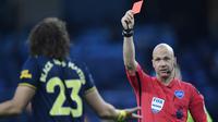 Wasit Anthony Taylor, memberikan kartu merah kepada bek Arsenal, David Luiz, saat pertandingan melawan Manchester City pada laga Premier League di Stadion Etihad, Rabu (17/6/2020). Manchester City menang 3-0 atas Arsenal. (AFP/Peter Powell)